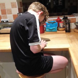 Boy Sat On Stool Slouching with Bad Posture